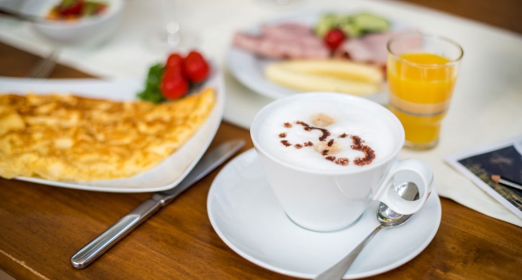 Gedeckter Frühstückstisch mit Omelette und Kaffeetasse